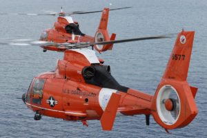 Two US Coast Guard helicopters flying over the ocean